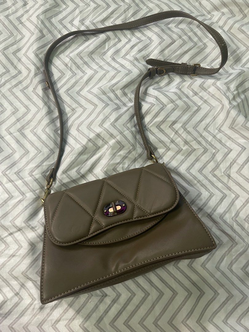 Charles & Keith Quilted Crossbody Bag (Category: Cross-body Bags) located in Navotas City. Submitted by itsjhen12 (Listing ID 1467705906, Image 1). Description: - Brand: Charles & Keith - Color: Elegant taupe brown - Material: Smooth, structured faux leather - Design: Quilted flap with a unique front twist lock closure - Hardware: Gold-tone metal accents and subtle gold branding on the back - Strap: Adjustable shoulder strap for a custom fit - Ca