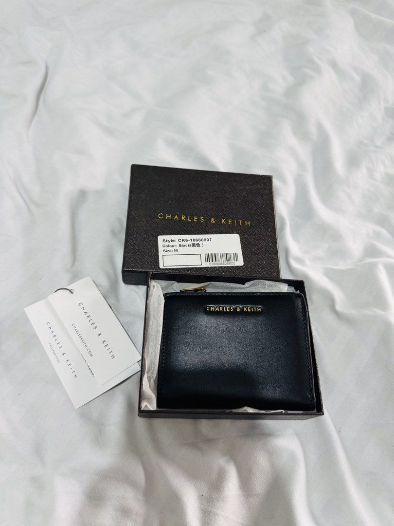 Charles & Keith Wallet CK6-10680907 Black M (Category: Wallets & Card holders) located in Pasig City. Submitted by marizanne04 (Listing ID 1467667021, Image 1). Description: - Brand: Charles & Keith - Style: CK6-10680907 (Medium) - Color: Classic Black with elegant gold-tone hardware and zip pull - Features: Interior card slots and a secure snap button pocket - Condition: Brand new, never used, and properly stored in its box - Inclusions: Comes w