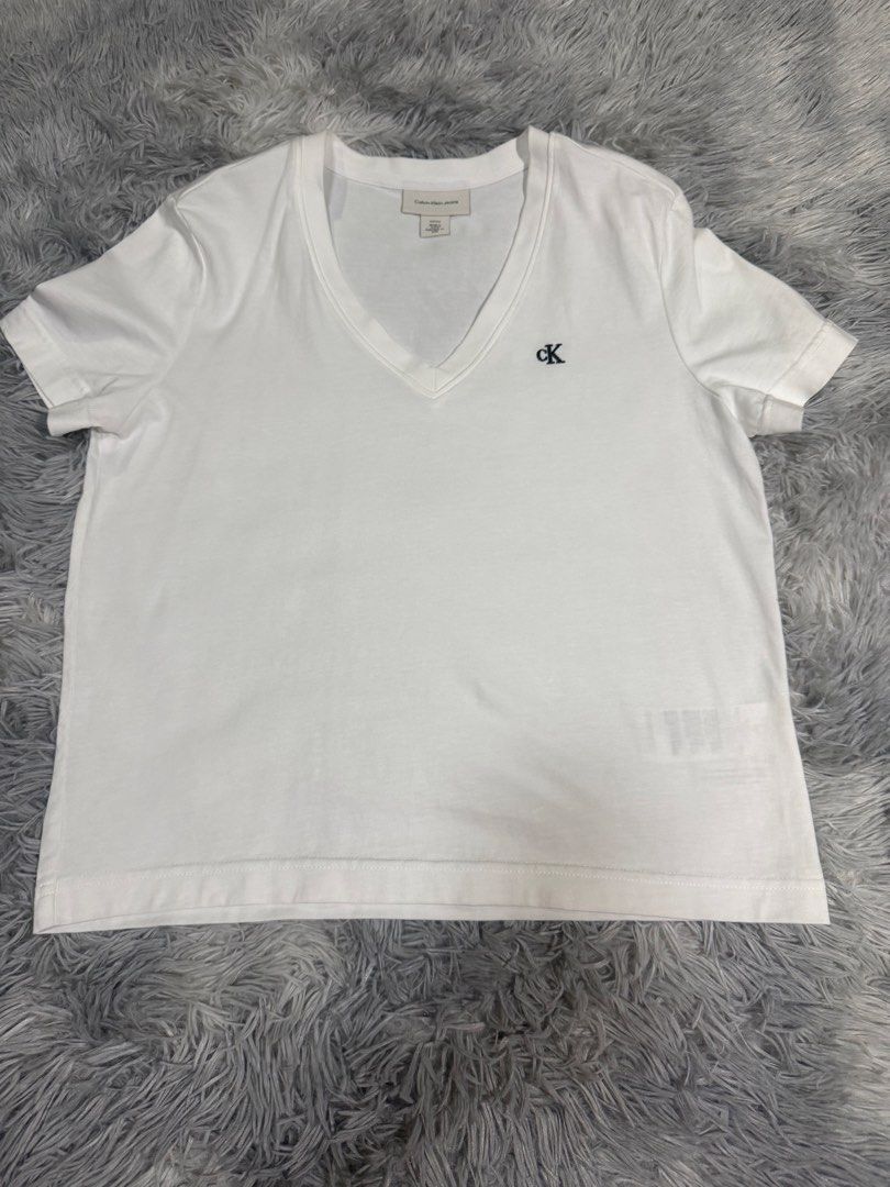CK Shirt for Women (White) (Category: Shirts) located in Muntinlupa City. Submitted by avampaya (Listing ID 1467761817, Image 1). Description: - Brand: Calvin Klein - Color: Classic White - Style: V-neck with short sleeves and ribbed collar - Size: S .