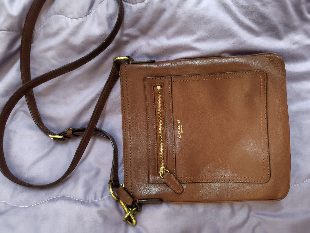 Coach Brown Leather Crossbody Bag (Category: Announcements) located in Angeles City. Submitted by MTstuffs (Listing ID 1467638520, Image 1). Description: - Brand: Coach - Material: Brown leather with cream fabric lining - Hardware: Gold-tone with signs of wear - Closure: Zipper top closure - Pockets: Convenient front zipper pocket - Strap: Adjustable brown strap with lobster clasps - Condition: Minor scuffs on the leather from normal wear - Size:
