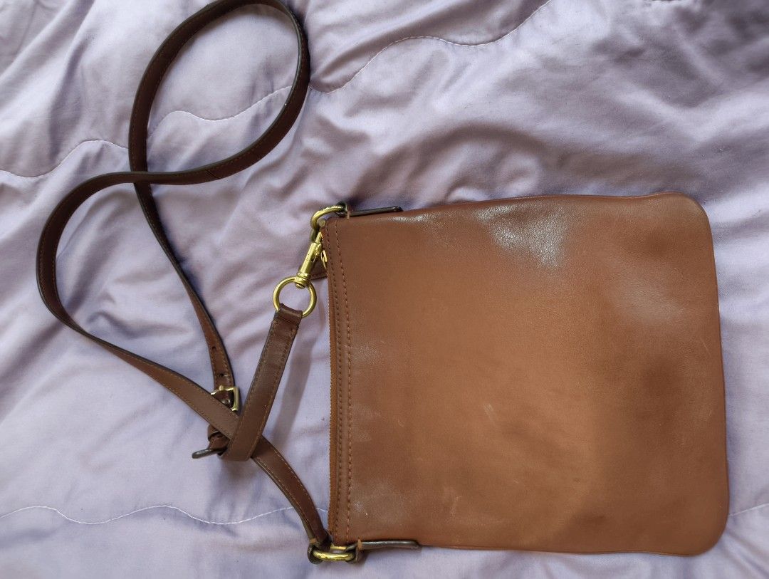 Coach Brown Leather Crossbody Bag (Category: Announcements) located in Angeles City. Submitted by MTstuffs (Listing ID 1467638520, Image 2). Description: - Brand: Coach - Material: Brown leather with cream fabric lining - Hardware: Gold-tone with signs of wear - Closure: Zipper top closure - Pockets: Convenient front zipper pocket - Strap: Adjustable brown strap with lobster clasps - Condition: Minor scuffs on the leather from normal wear - Size: