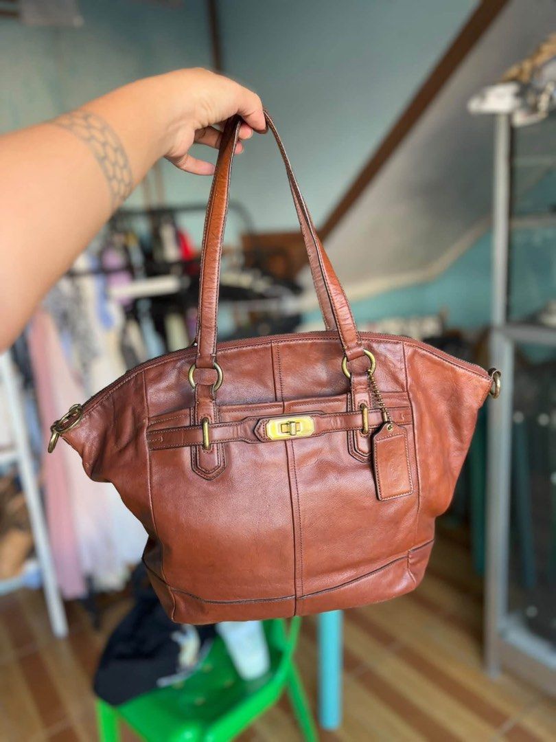 Coach Brown Leather Shoulder Bag (Category: Luxury Bags & Wallets) located in Manila. Submitted by meegy (Listing ID 1467622684, Image 1). Description: - Authentic Coach shoulder bag in rich brown leather - Brass hardware accents and classic turn-lock front detail - Dual shoulder straps for comfortable daily wear - Secure zip top closure - Fabric-lined interior featuring a handy zip pocket - Includes original hanging leather Coach tag - Condition