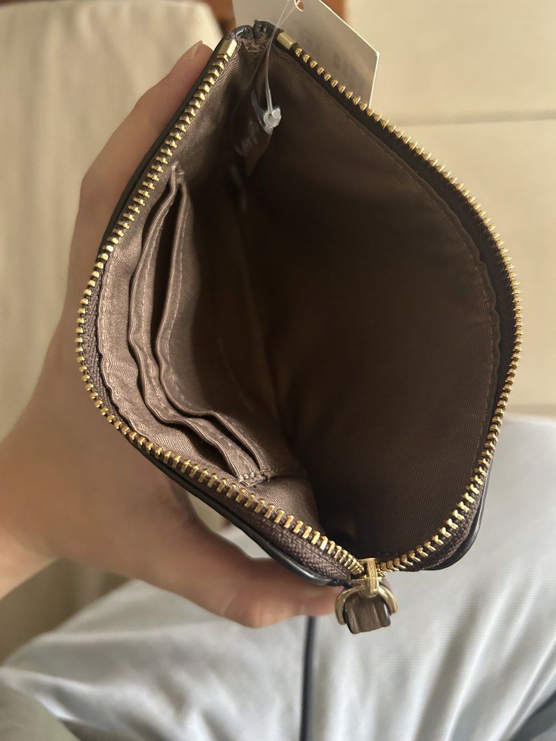 Coach Brown Leather Wristlet (Category: Purses & Pouches) located in Pasig City. Submitted by piayayaya511 (Listing ID 1467607985, Image 2). Description: - Brand: Coach - Material: Premium brown pebbled leather - Hardware: Elegant gold-tone - Features: Secure zip-top closure, attached wrist strap, and fabric-lined interior with two card slots - Condition: Brand new with original tag still attached - Details: Smooth zipper pull and clean, high-qua
