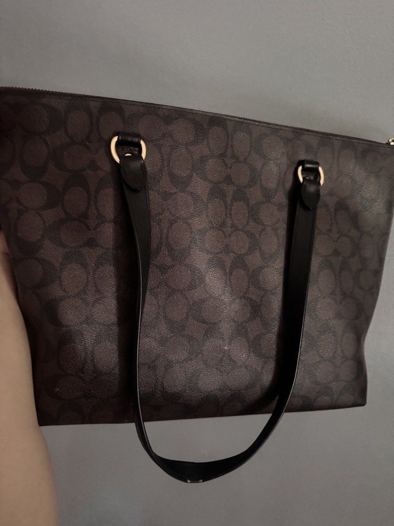 Coach Brown Signature Monogram Tote Bag (Category: Luxury Bags & Wallets) located in Cebu City. Submitted by ixiaces (Listing ID 1467652138, Image 3). Description: - Authentic Brown Coach Tote Bag with Signature Monogram Print - Stylish black leather shoulder straps with gold-tone hardware - Top zipper closure and handy front zip pocket with matching pull - Includes a cute bonus nurse keychain attached to the strap rings - Condition: Minor wear s