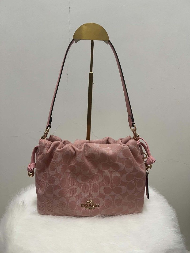 Coach Faye Shoulder Bag (Category: Shoulder Bags) located in Paoay. Submitted by rvf1230 (Listing ID 1467645917, Image 2). Description: - Authentic pink Coach shoulder bag with signature C monogram canvas - Chic gold-tone hardware and matching pink leather trim - Secure drawstring top closure with cute knotted pull details and branded hangtag - Comes with an adjustable and removable long strap for shoulder or crossbody wear - Clean pink base stru