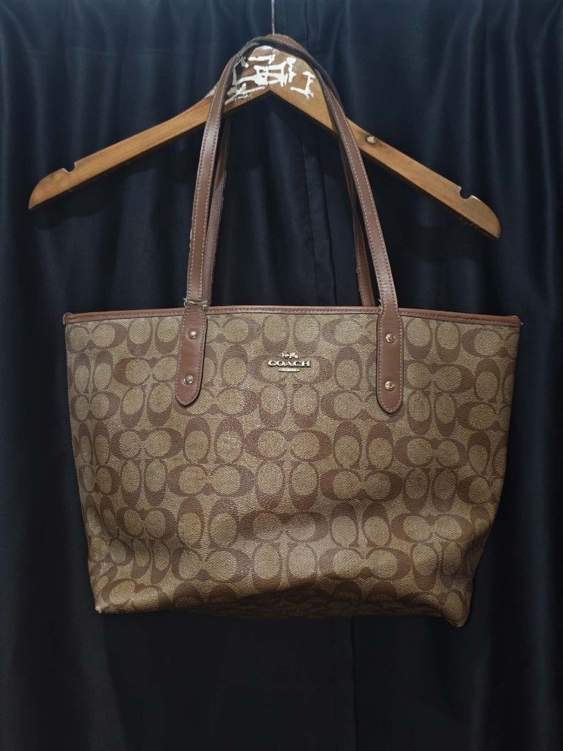 Coach Signature Brown Monogram Tote Bag (Category: Luxury Bags & Wallets) located in Baguio. Submitted by solo_ukay (Listing ID 1467778107, Image 2). Description: - Authentic Coach Signature Monogram Tote Bag (Style F58292) - Classic brown canvas exterior with gold-tone Coach logo lettering - Dual leather shoulder straps with stylish hardware details - Brown fabric-lined interior featuring a convenient zip pocket and Coach storypatch - Condition: