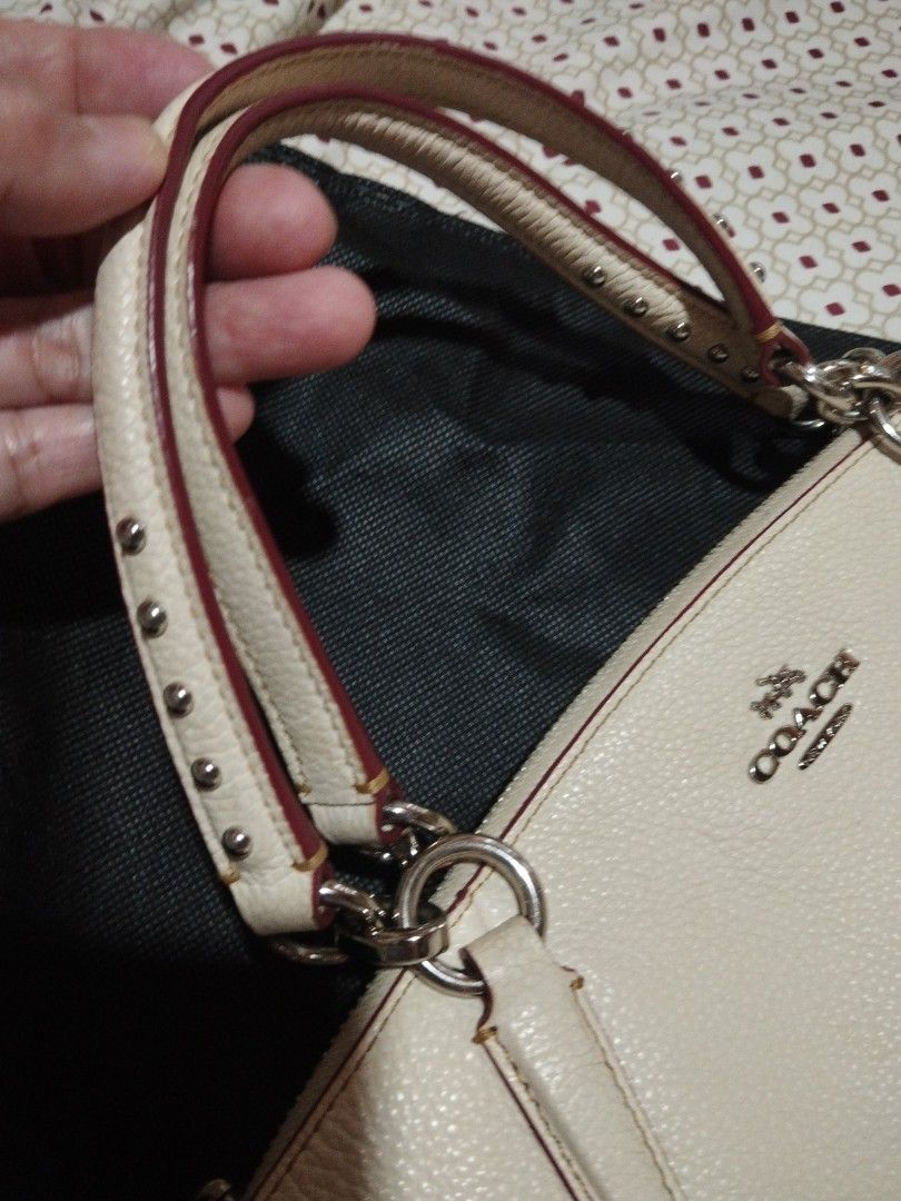 Coach White Leather Studded Handbag with Shoulder Strap (Category: Luxury Bags & Wallets) located in Manila. Submitted by lene48 (Listing ID 1467729119, Image 3). Description: - Authentic Coach white pebbled leather handbag - Features stylish decorative metal studs and red jewel accents near the bottom corners - Dual top handles with contrast red edge trimming - Includes a detachable long shoulder strap for versatile wear - Secure zippered top cl