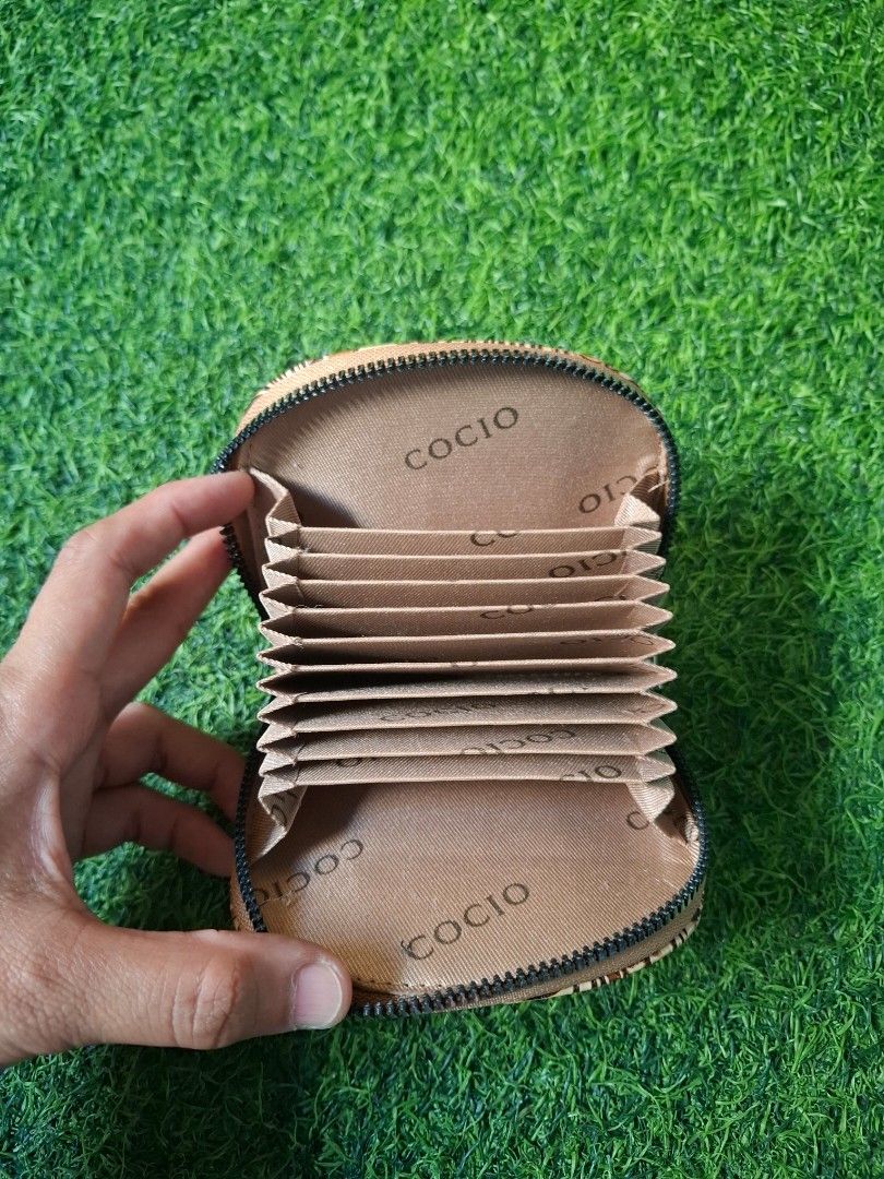 Cocio Floral Embossed Leather Card Wallet (Category: Wallets & Card holders) located in Pasay City. Submitted by emilia1102 (Listing ID 1467798100, Image 2). Description: - Tan card wallet with stylish floral tooling - Accordion-style interior slots featuring 'Cocio' pattern - Secure zipper closure with metal pull tab - Compact and handy for organizing multiple cards - Original price: ₱380 | Selling price: ₱200.