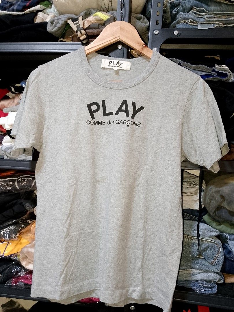 COMME des GARCONS PLAY grey t-shirt large (Category: Shirts) located in Manila. Submitted by mjthrifted_second (Listing ID 1467647180, Image 1). Description: - Brand: PLAY Comme des Garçons - Color: Grey - Size: Tagged L -Dimes: 18/24 - Design: Big black heart graphic on back with PLAY COMME des GARÇONS text logo on the chest - Material: 100% cotton - Origin: Made in Japan - Condition: Clean neck tag and wash label included.