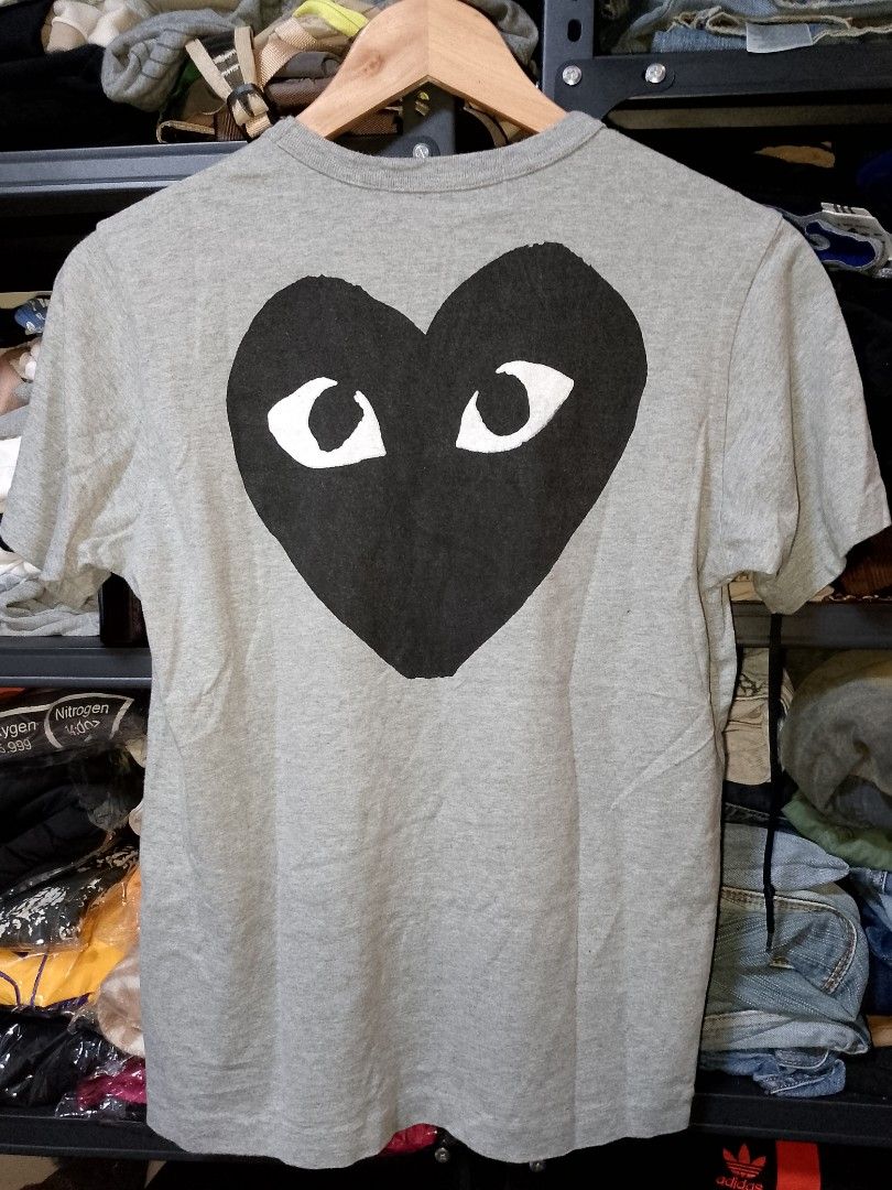 COMME des GARCONS PLAY grey t-shirt large (Category: Shirts) located in Manila. Submitted by mjthrifted_second (Listing ID 1467647180, Image 2). Description: - Brand: PLAY Comme des Garçons - Color: Grey - Size: Tagged L -Dimes: 18/24 - Design: Big black heart graphic on back with PLAY COMME des GARÇONS text logo on the chest - Material: 100% cotton - Origin: Made in Japan - Condition: Clean neck tag and wash label included.