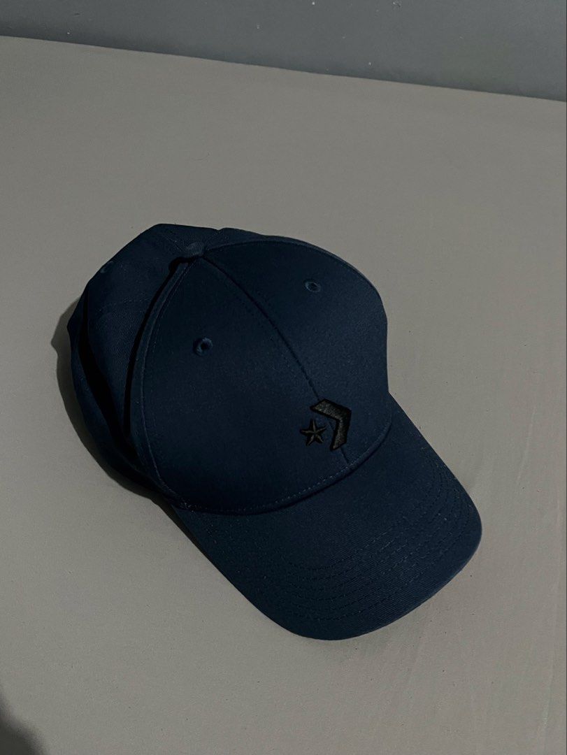 Converse Adjustable Cotton Twill Unisex Cap (Blue Opal) (Category: Caps & Hats) located in Taguig. Submitted by csthejustin (Listing ID 1467740700, Image 1). Description: - Color: Navy Blue (worn once only) - Style: Baseball cap with adjustable strap - Details: Embroidered star chevron logo on front and Converse lettering on the back strap - Size: One size fits all - Condition: Clean fabric, tags with care instructions intact.