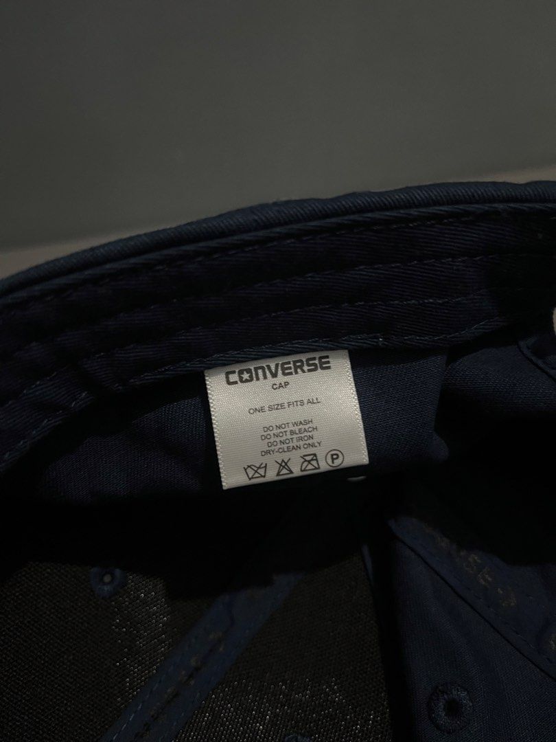 Converse Adjustable Cotton Twill Unisex Cap (Blue Opal) (Category: Caps & Hats) located in Taguig. Submitted by csthejustin (Listing ID 1467740700, Image 2). Description: - Color: Navy Blue (worn once only) - Style: Baseball cap with adjustable strap - Details: Embroidered star chevron logo on front and Converse lettering on the back strap - Size: One size fits all - Condition: Clean fabric, tags with care instructions intact.