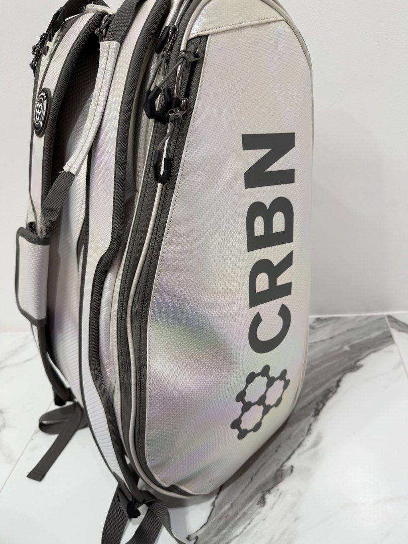 CRBN Pickleball Bag White Backpack (Category: Other Sports Equipment and Supplies) located in Valenzuela. Submitted by alyssa_3 (Listing ID 1467748495, Image 3). Description: - Brand: CRBN Pickleball Backpack - Color: Eye-catching white iridescent material - Storage: Large main compartment, side mesh pockets, plenty of space for multiple paddles and gear - Comfort: Padded shoulder straps with a magnetic closure detail - Condition: Clean interior 