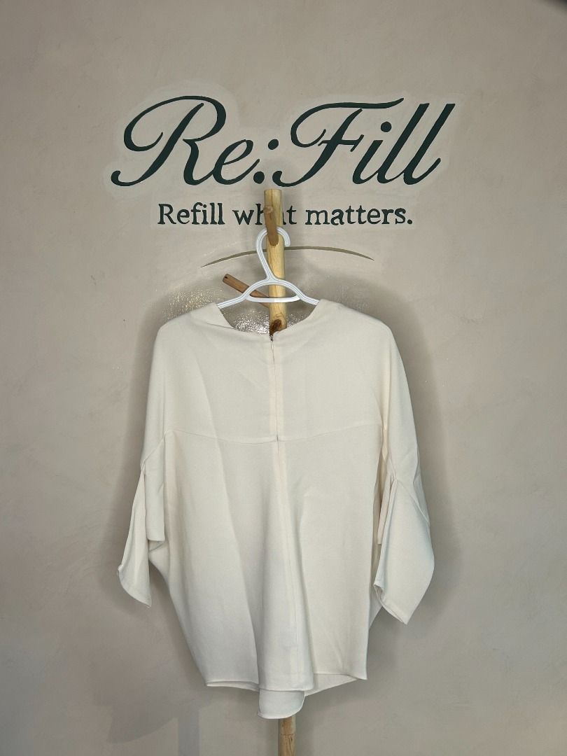 Cream batwing sleeve top with V-neck (Category: Blouses) located in Taguig. Submitted by re.wear.mnl (Listing ID 1467707211, Image 2). Description: - Color: Cream / Neutral - Style: Batwing top with V-neckline - Fit: Loose, relaxed fit with half-length sleeves - Details: Smooth fabric texture and back zipper closure - Versatility: Easy to pair with trousers or skirts - Care: Hand wash cold, flat dry only.