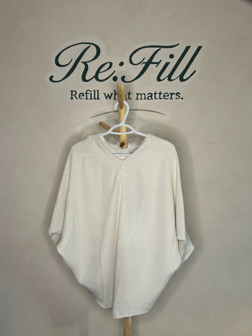 Cream batwing sleeve top with V-neck (Category: Blouses) located in Taguig. Submitted by re.wear.mnl (Listing ID 1467707211, Image 1). Description: - Color: Cream / Neutral - Style: Batwing top with V-neckline - Fit: Loose, relaxed fit with half-length sleeves - Details: Smooth fabric texture and back zipper closure - Versatility: Easy to pair with trousers or skirts - Care: Hand wash cold, flat dry only.