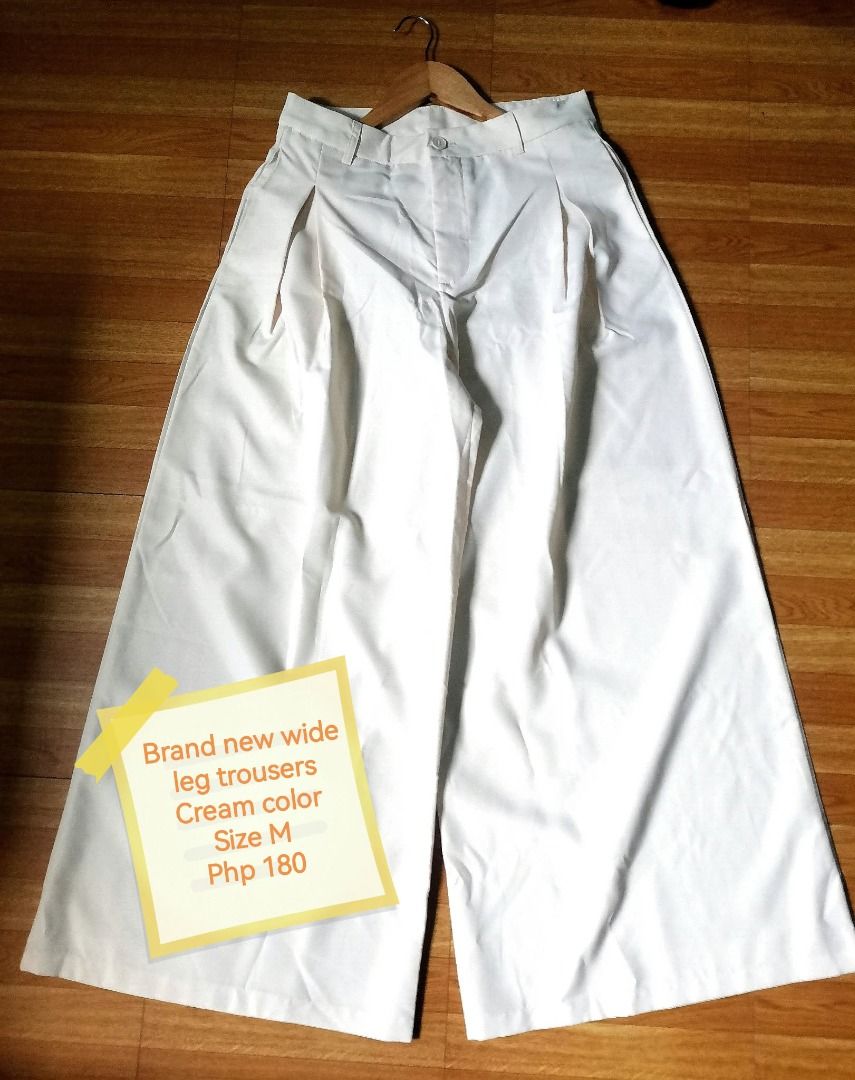 Cream wide leg trousers (Category: Jeans) located in Manila. Submitted by mahanaim.67c328 (Listing ID 1467759981, Image 1). Description: - Size: M - Color: Cream - Material: 100% polyester - Design: Pleated front with zipper fly and button closure - Style: Versatile for casual or formal wear .