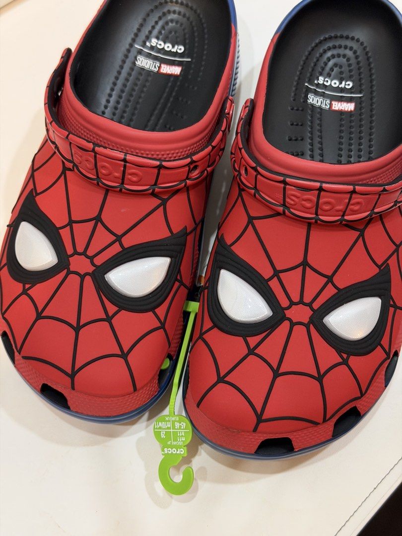 Crocs Marvel Studios Spider-Man Clogs (Category: Slippers & Slides) located in Las Pinas. Submitted by thereng (Listing ID 1467749846, Image 1). Description: Brand new with store hanger attached. Size US M11 / W11, EUR 45-46. Ordered from US. Marvel Studios Spider-Man Crocs clogs. Red upper with black web pattern and white eye details. Classic slip-on design with pivoting heel strap. .
