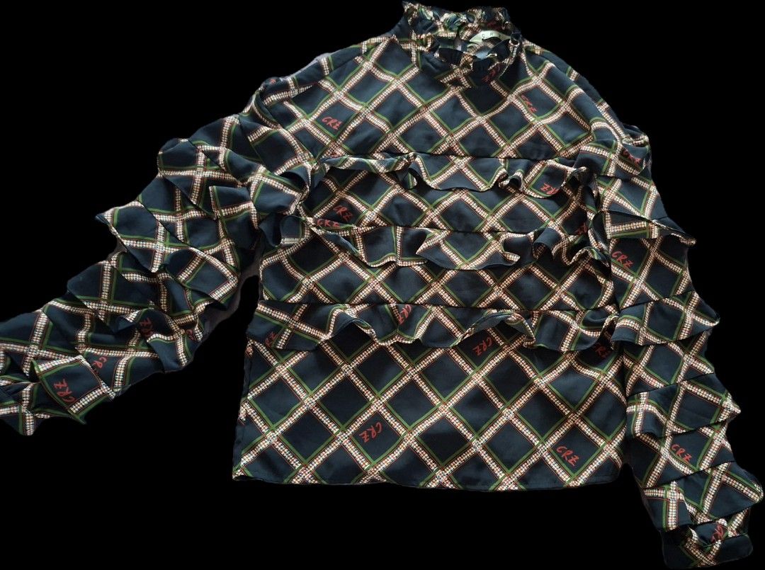 CRZ patterned ruffle long sleeve blouse mock neck (Category: Blouses) located in Las Pinas. Submitted by melsv (Listing ID 1467693994, Image 1). Description: - Color: Dark green and black plaid with subtle red 'CRZ' print - Design: Allover layered ruffles on chest and sleeves - Neckline: High mock collar with gathered ruffling - Sleeves: Long sleeves with lightweight fabric - Quality: Clean stitching and hems throughout.