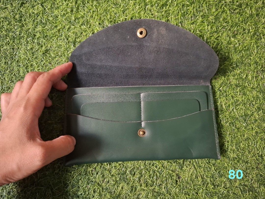 Dark Green Leather Long Wallet With Flower Snap Button (Category: Wallets & Card holders) located in Pasay City. Submitted by emilia1102 (Listing ID 1467798370, Image 2). Description: - Color: Dark green with matching interior lining - Material: Sleek long leather with clean edge stitching - Closure: Flap closure with a vintage-style bronze flower button snap - Interior: Multiple card slots and a spacious main compartment - Design: Slim profile t