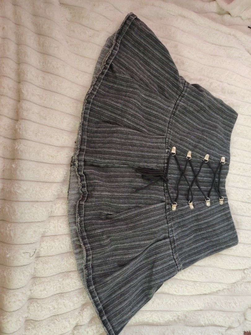 Dark Grey Pinstripe Laced Mini Skirt (Category: Skirts) located in Mabalacat. Submitted by Jackikay.PreLoved (Listing ID 1467619232, Image 1). Description: - Color: Dark grey with white pinstripes - Style: Y2K alternative, flared hem with slight raw edge - Details: Front lace-up black cord with silver-tone eyelets - Closure & Lining: Convenient side zipper and comfortable black inner lining - Styling: Pairs amazingly with boots or platform shoes 
