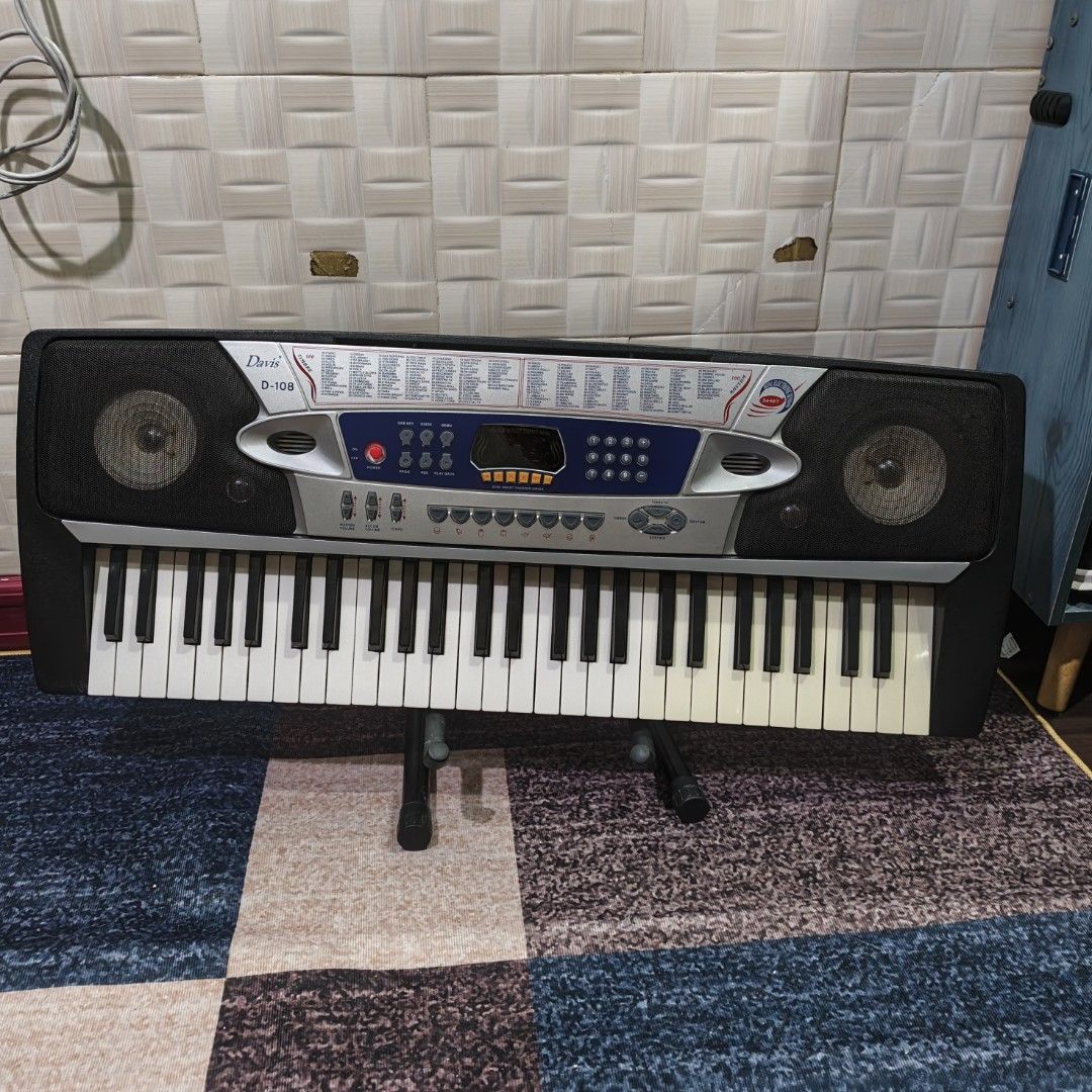 Davis D-108 54-Key Electronic Keyboard (Category: Musical Instruments) located in Manila. Submitted by queenofthesea0202 (Listing ID 1467644985, Image 3). Description: - Model: Davis D-108 Electronic Keyboard - Keyboard: 54 keys with built-in speakers and LED display - Sounds & Rhythms: 100 timbres, 100 rhythms, and 8 demo songs - Power Options: Runs on 6 D batteries or DC 9V power supply - Inclusions: Keyboard stand included - Condition: Great f
