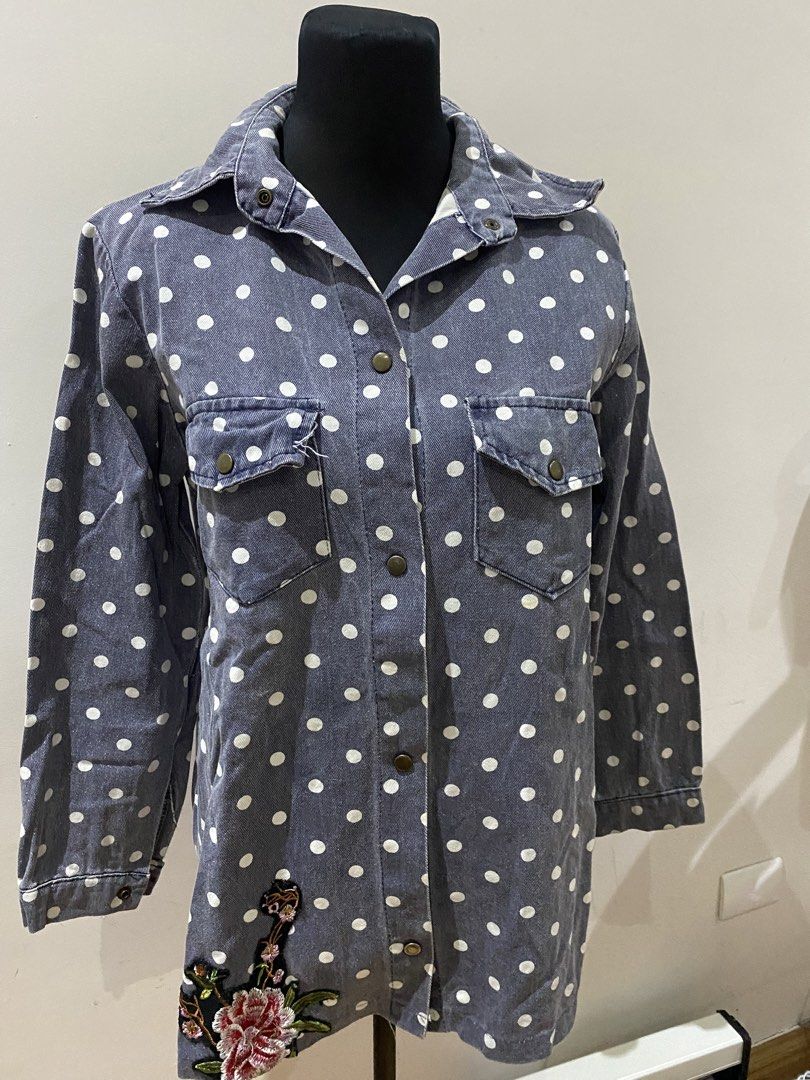 Denim jacket polka dot with floral embroidery (Category: Coats, Jackets and Outerwear) located in Manila. Submitted by mpt99876 (Listing ID 1467796413, Image 1). Description: - Style: Grey denim button-up shirt or lightweight jacket - Pattern: All-over white polka dots with floral embroidery near the hem - Pockets: Two chest pockets with button flaps - Sleeves: Long sleeves with button cuffs - Fit: Comfortable relaxed fit with a classic collared 