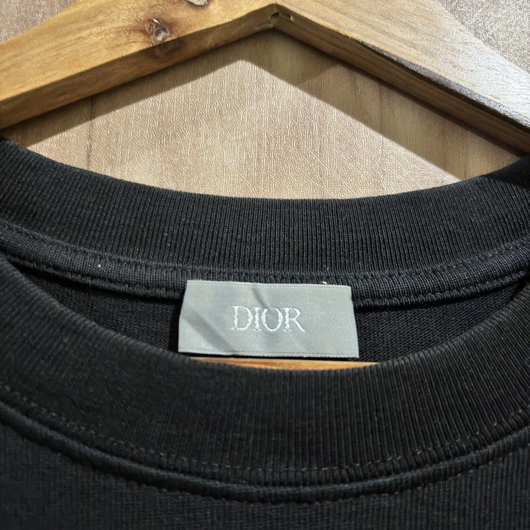 Dior Buffalo Embroidered Black T-shirt (Category: Tshirts & Polo Shirts ) located in Batangas. Submitted by phthriftpingzz (Listing ID 1467696421, Image 3). Description: - Brand: Dior - Color: Black - Size: L - Material: 100% Cotton, Made in Italy - Design: Buffalo chest patch with text pattern & blue embroidered Dior branding on the right sleeve - Fit: Crew neck, short sleeves - Condition: Clean fabric and solid construction.