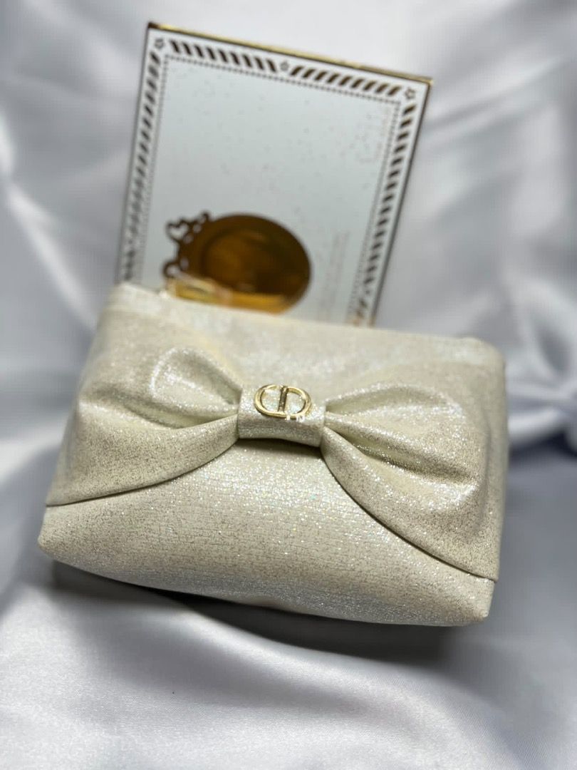 Dior Makeup Pouch Vanity Medallion 2026 (Category: Purses & Pouches) located in Makati City. Submitted by mariaasevilla0622eb (Listing ID 1467762090, Image 2). Description: - Authentic Dior cosmetic bag in a gorgeous shimmery beige shade - Features a chic large front bow accented with gold-tone CD logo hardware - Includes a round Dior zipper pull and a matching detachable star charm keychain - Clean interior lining complete with the official Dior