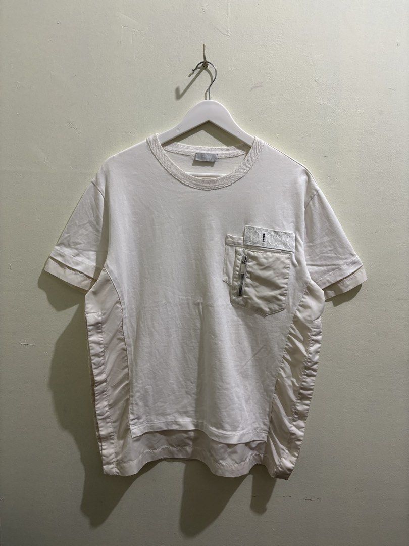 Dior x Sacai (Category: Tshirts & Polo Shirts ) located in Daraga. Submitted by hannieldustin (Listing ID 1467634884, Image 1). Description: - Brand: Dior - Color: White - Size: Medium (M) - Material: 100% Cotton, Made in Italy - Features: Chest pocket with zip compartment, embroidered Dior branding, and unique layered fabric paneling down both sides - DM for measurements or fast shipping!.