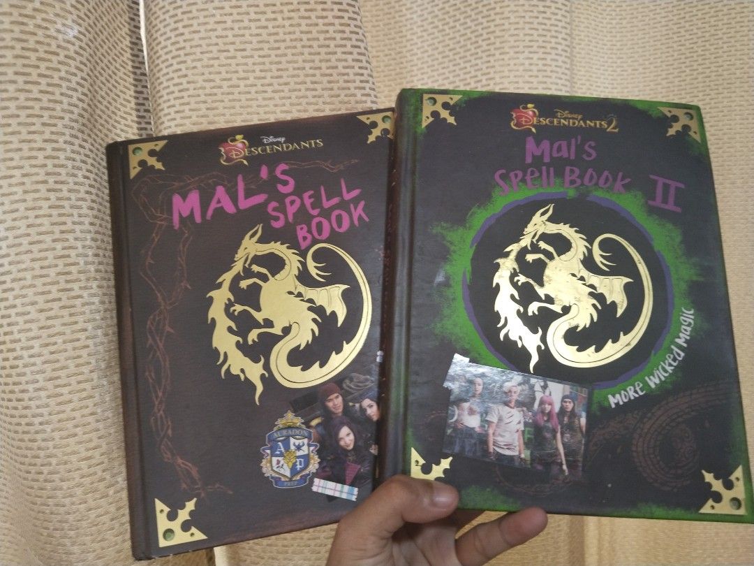 Disney Descendants Mal's Spell Book Bundle (Category: Children's Books) located in Cavite. Submitted by munting_aklatan_ph (Listing ID 1467653124, Image 1). Description: - Item: Bundle Disney Descendants Mal's Spell Book and Spell Book II (Hardback) - Condition: Clean pages inside with a solid spine, corner cover with minor fraying due to storage - Features: Filled with notes, spells, and doodles from your favorite VKs - Ideal for: Fans of the Di