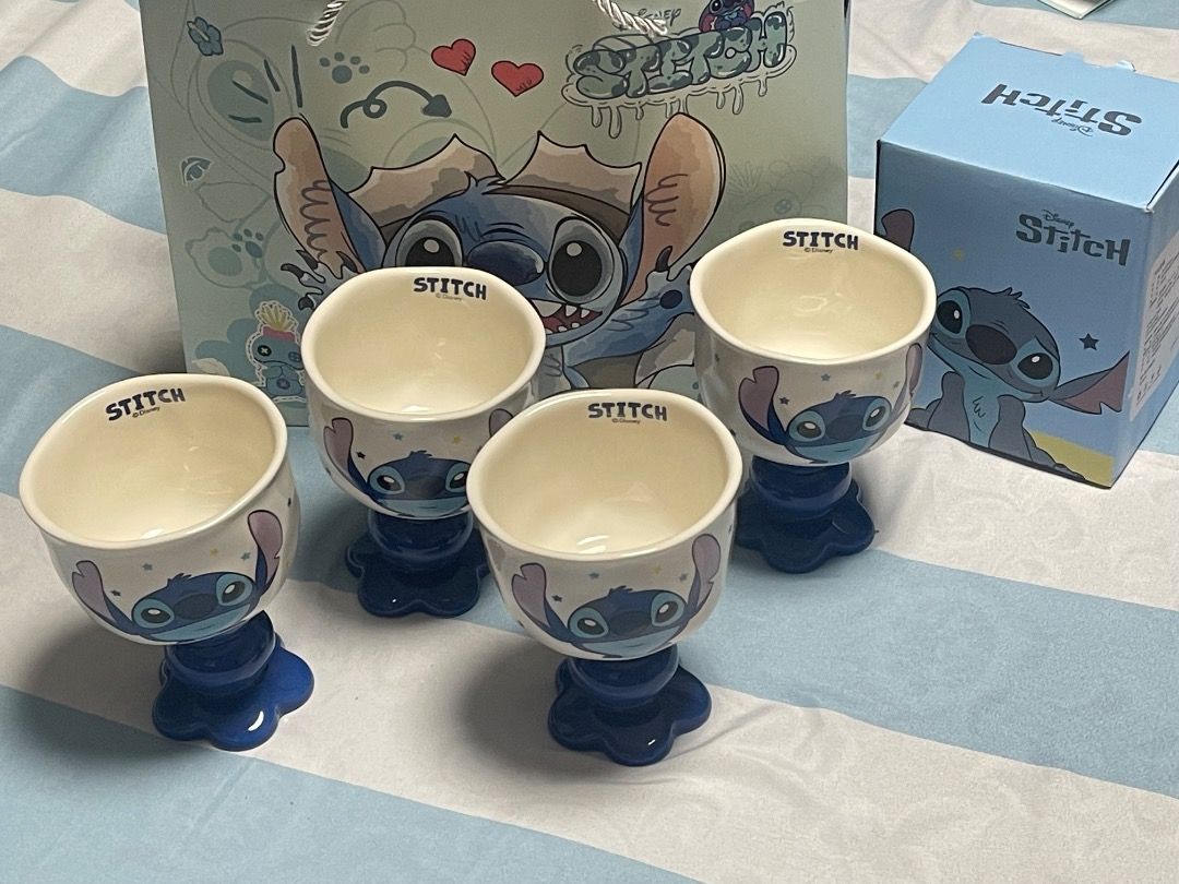 Disney Stitch Ceramic Goblet Cups Set with Box and Bag (Category: Coffee & Tea Tableware) located in Subic. Submitted by anything_lovely_under_the_sun (Listing ID 1467758326, Image 2). Description: - Set of 4 adorable Disney Stitch ceramic goblet cups - Features cute Stitch graphics and a stylish blue flower base - Comes with individual blue packaging boxes and a matching Stitch paper gift bag - Perfect for Disney fans or everyday use - Clean con