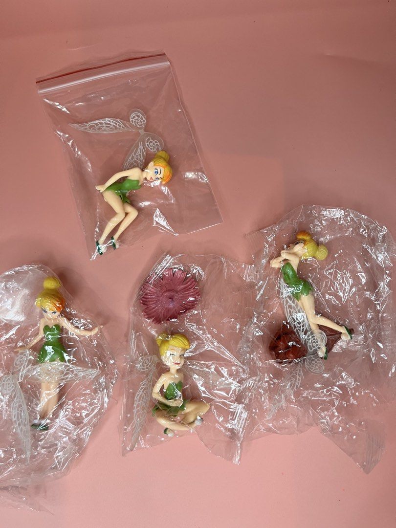 Disney Tinker Bell Figurines Set with Accessories (Category: Figurines & Statues) located in Caloocan City. Submitted by snapshop_ph (Listing ID 1467644612, Image 1). Description: - Set of 4 Tinker Bell figures in individual plastic bags - Features assorted poses: sitting, standing, and reclining - Includes a pink flower accessory and a brown base piece - Detailed green dresses and translucent wings - Great addition to any Disney collection or as