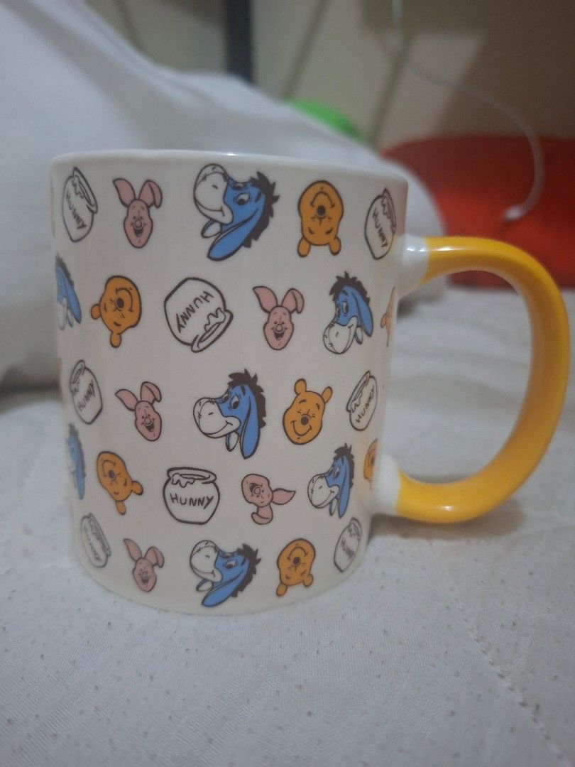 Disney Winnie the Pooh Mug (Category: Coffee & Tea Tableware) located in Consolacion. Submitted by luxekerei (Listing ID 1467608299, Image 2). Description: - the Daiso × Disney Winnie the Pooh 350ml Ceramic Mug featuring an all-over pattern of Pooh, Piglet, Eeyore, and "Hunny" pots with a yellow handle..