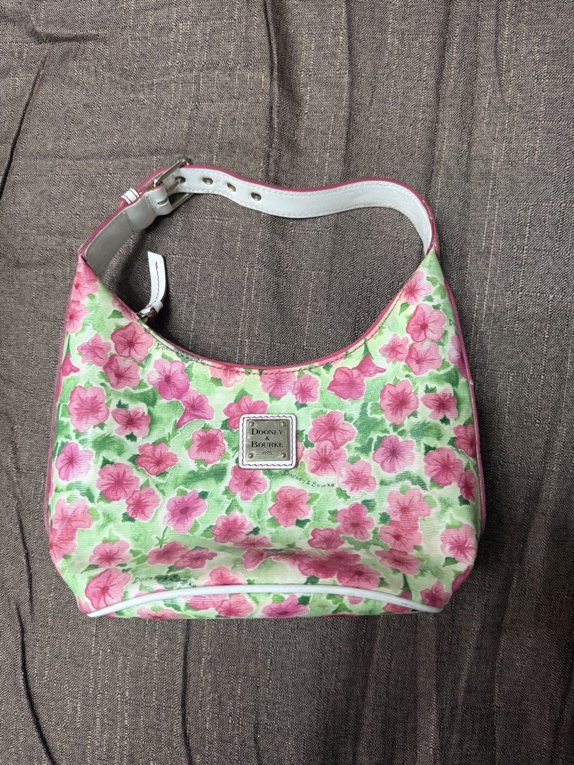 Dooney & Bourke Floral Shoulder Bag (Category: Luxury Bags & Wallets) located in Cainta. Submitted by amswardrobe (Listing ID 1467836248, Image 3). Description: - Brand: Dooney & Bourke - Design: Colorful pink and green floral print on clean canvas - Strap: Adjustable white leather strap with buckle hardware - Hardware & Logo: Metal logo plaque on the front - Closure: Secure zip-top closure - Interior: Red fabric lining with convenient slip pocke