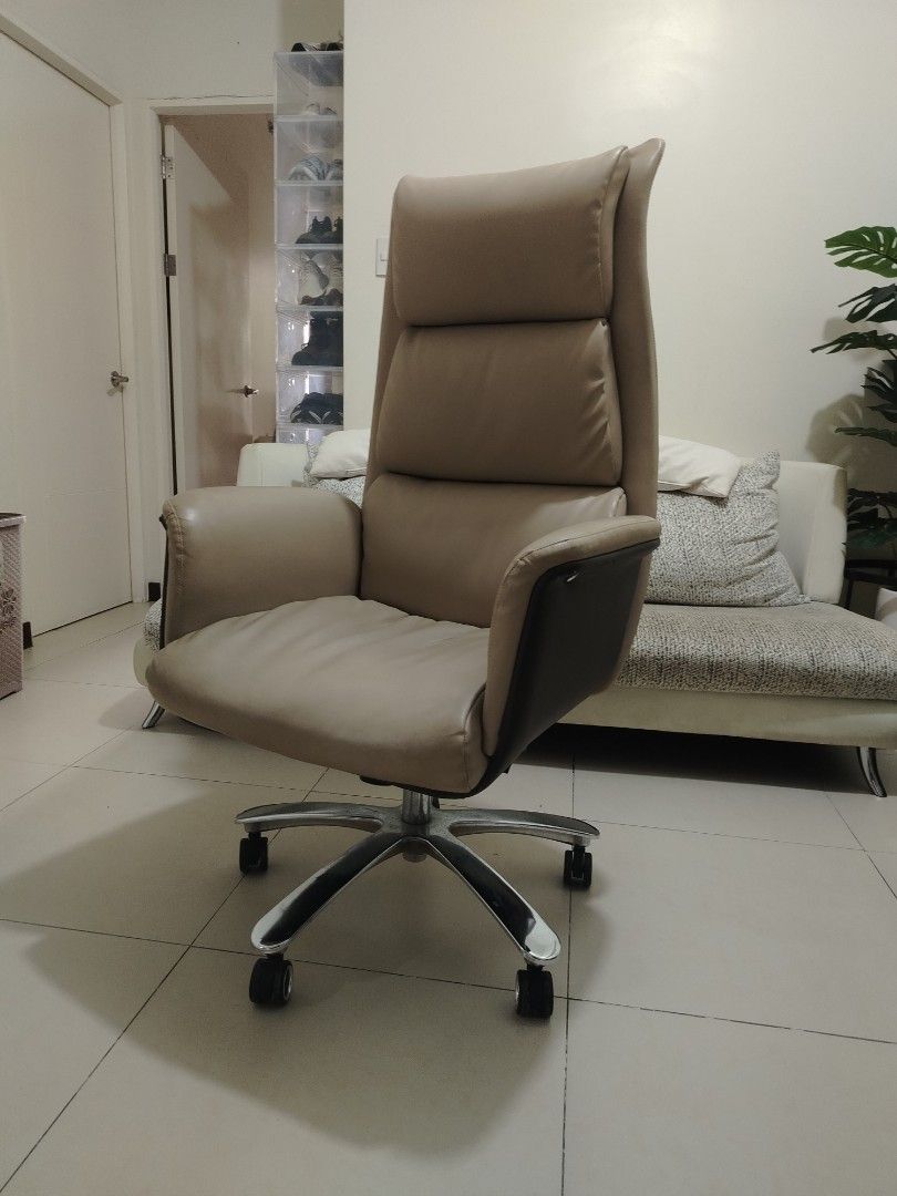 Ergonomic High Back Executive Office Chair Beige Brown (Category: Office Furniture & Fixtures) located in Pasig City. Submitted by juniort2001 (Listing ID 1467668908, Image 1). Description: - Elegant executive high-back office chair in beige and dark brown leatherette - Thick padded cushioning on the seat, backrest, and headrest for maximum all-day support - Sturdy chrome star base equipped with smooth-rolling caster wheels - Fully functional hei