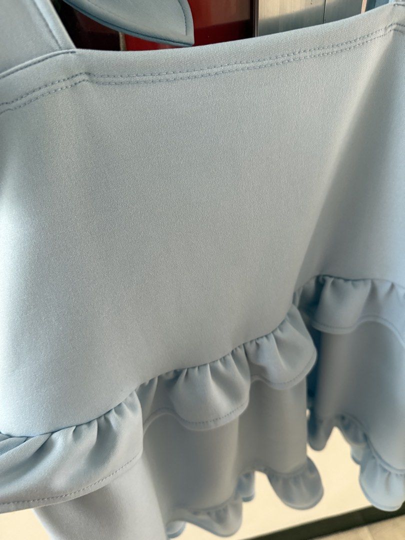 Everyday Casuals Light Blue Ruffle Tiered Cami Top (Category: Sleeveless) located in Mandaluyong City. Submitted by declutteringmylife101 (Listing ID 1467634553, Image 2). Description: - Brand/Style: Light blue cami top from Everyday Casuals - Design: Layered ruffles on front and back with adjustable self-tie ribbon straps - Cut: Straight neckline and sleeveless - Fabric: Soft, lightweight, and flowy material ideal for warm weather.