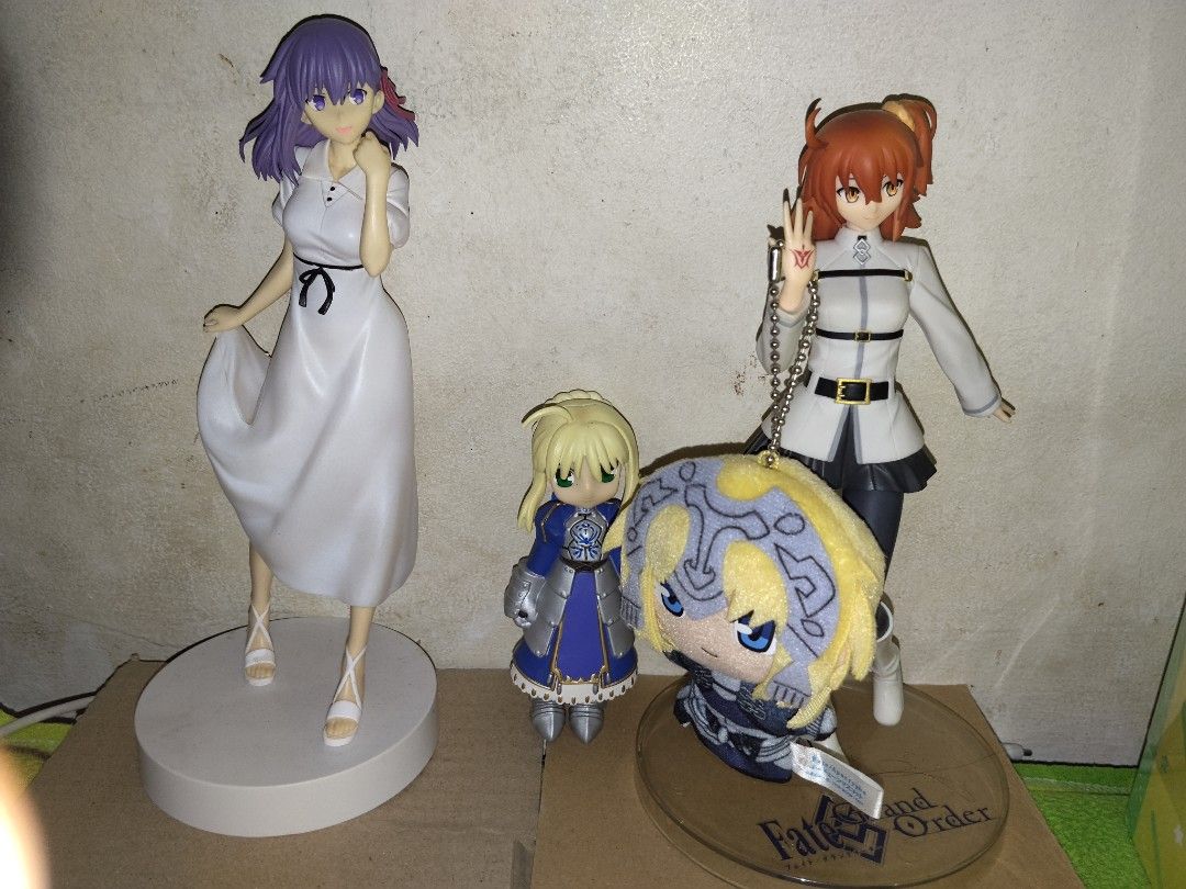 Fate Grand Order Figure Bundle (Category: Figurines & Statues) located in Manila. Submitted by castergil (Listing ID 1467712420, Image 1). Description: - Official Fate/Grand Order merchandise collection - Includes: Sakura Matou white dress figure, Artoria Pendragon chibi, Ritsuka Fujimaru figure, and Jeanne d'Arc plush keychain - Note: Original boxes are missing - Perfect set for FGO collectors and fans looking to expand their display.