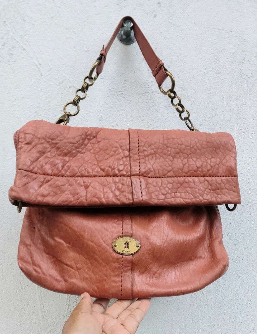 Fossil Leather Shoulder Bag with Key Charm (Category: Shoulder Bags) located in Lapu Lapu. Submitted by agnesapm_29813 (Listing ID 1467733235, Image 3). Description: - Authentic Fossil leather shoulder bag in rustic coral pink - Versatile fold-over design (wear extended or folded down) - Brass-tone chain strap hardware and matching key charm - Iconic Fossil keyhole logo plate on the front - Crafted from soft, textured leather with natural crinkle