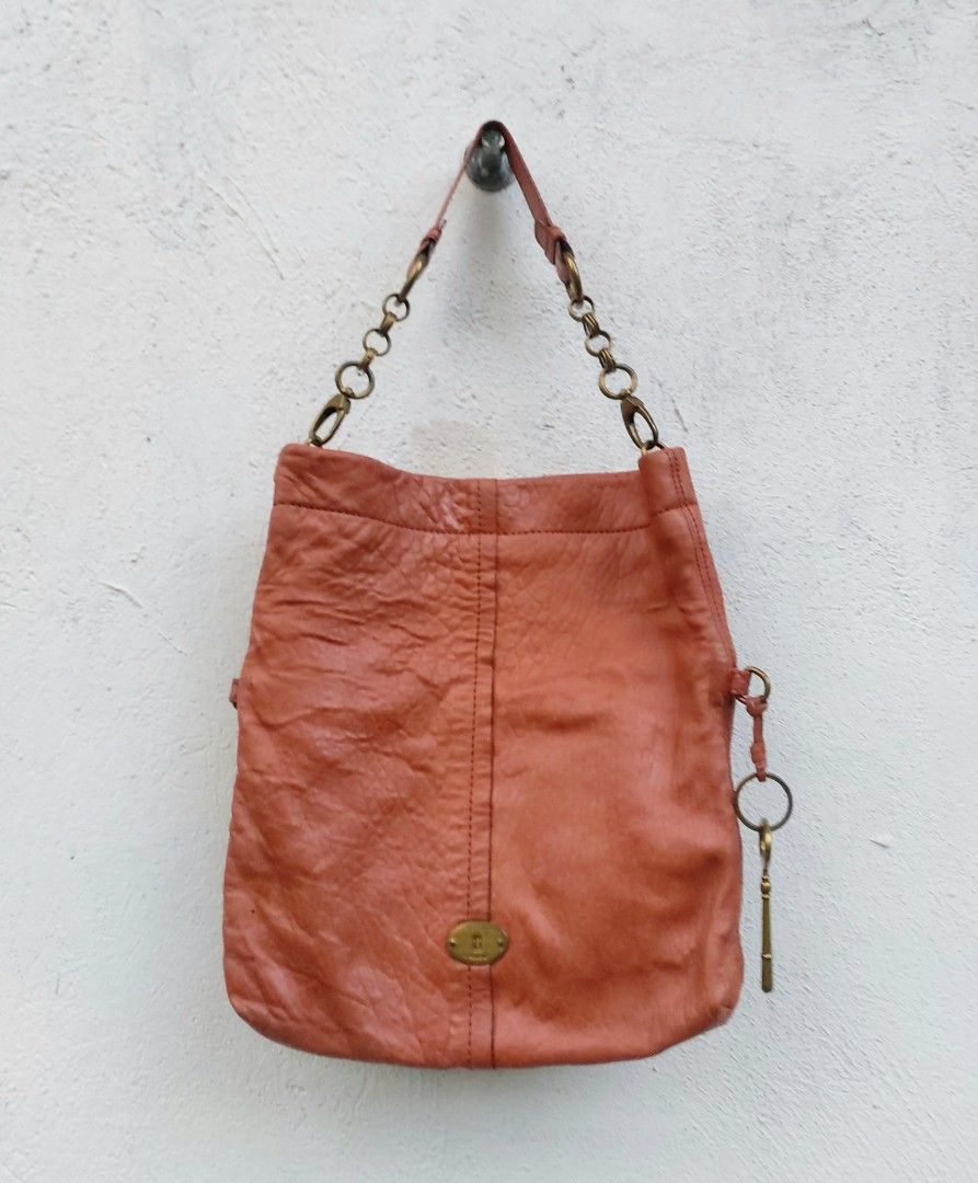 Fossil Leather Shoulder Bag with Key Charm (Category: Shoulder Bags) located in Lapu Lapu. Submitted by agnesapm_29813 (Listing ID 1467733235, Image 1). Description: - Authentic Fossil leather shoulder bag in rustic coral pink - Versatile fold-over design (wear extended or folded down) - Brass-tone chain strap hardware and matching key charm - Iconic Fossil keyhole logo plate on the front - Crafted from soft, textured leather with natural crinkle