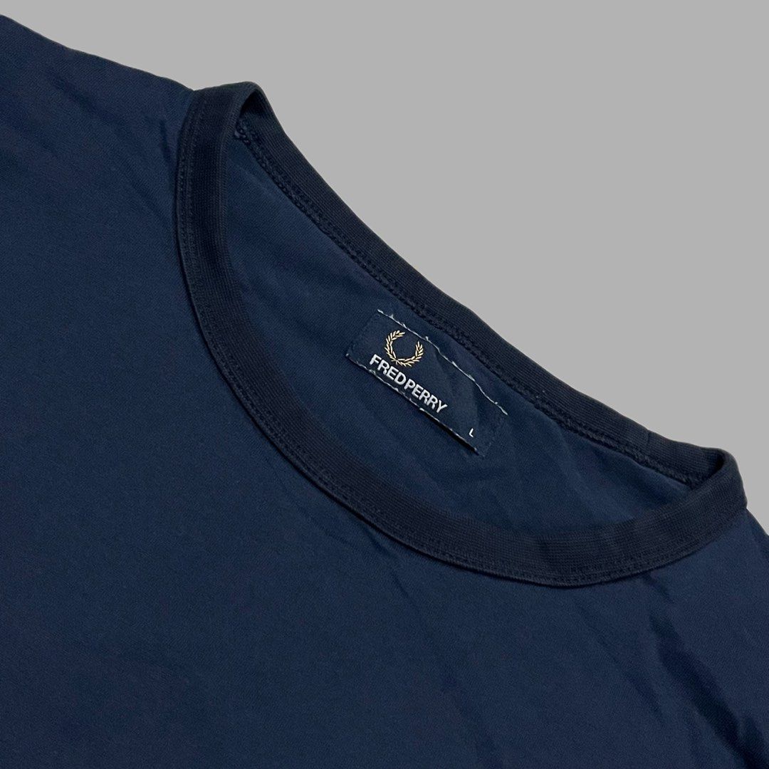 Fred Perry Navy Blue T-Shirt Size L (Category: Tshirts & Polo Shirts ) located in Manila. Submitted by frenzyyyy (Listing ID 1467627102, Image 3). Description: - Brand: Fred Perry - Style: Classic crew neck basic t-shirt - Color: Dark navy blue - Size: L - Dimes: 21/28.5 - Material: Comfortable, high-quality cotton - Details: Iconic embroidered laurel wreath logo on the chest, ribbed collar and sleeve cuffs - Condition: Clean and well-maintained 