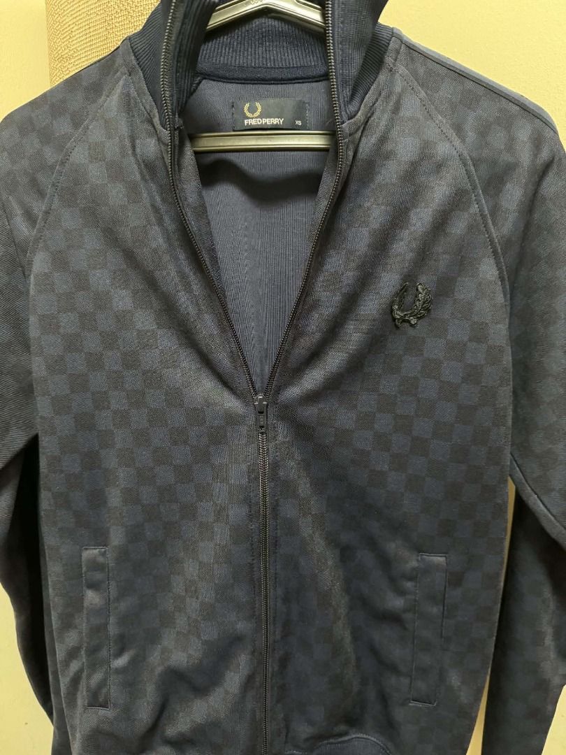 Fred Perry Navy Jacket Size XS (Category: Coats, Jackets and Outerwear) located in Quezon City. Submitted by chadermeister (Listing ID 1467730656, Image 1). Description: - Brand: Fred Perry - Color: Navy -Chequerboard print - Size: XS (tag stitched inside collar) - Material/Texture: Ribbed fabric with classic knit collar - Detail: Embroidered laurel wreath logo - Condition: Clean overall, great casual staple.