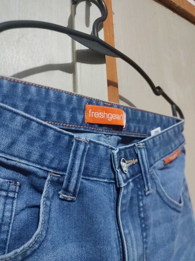 Freshgear Blue Denim Jeans Straight Cut (Category: Jeans) located in Manila. Submitted by jakelauren63238 (Listing ID 1467646007, Image 3). Description: - Brand: Freshgear - Color/Wash: Medium wash blue denim - Fit: Straight cut - Details: Subtle distressed accents on thighs, classic five-pocket style, button closure, standard belt loops, and signature orange logo tag inside the waistband - Style: Versatile and perfect for daily outfits.
