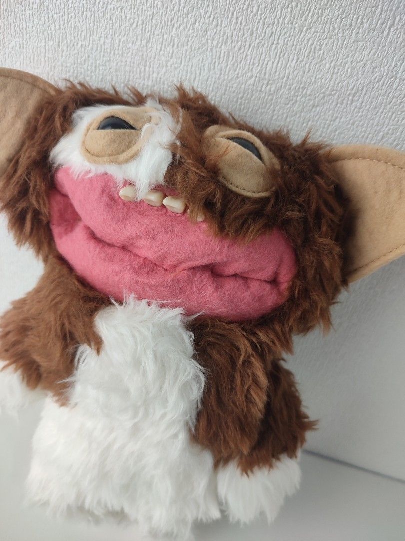 Fugglers x Gremlins Gizmo Plush Toy (Category: Plushies & Soft Toys) located in Manila. Submitted by epicmountain-f20453 (Listing ID 1467732099, Image 2). Description: Fugglers collaboration with Gremlins. Gizmo character featuring soft brown and white fur, felt ears, and realistic human-like teeth. Includes the original tag attached to the side showing Zuru and Spin Master licensing. Clean condition with no damage or stains observed on the fabri