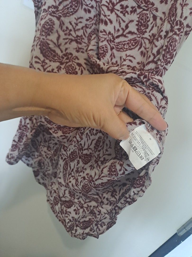 Gap paisley print sleeveless (Category: Sleeveless) located in Manila. Submitted by joanbalde39643 (Listing ID 1467658987, Image 3). Description: This is an Old Navy high-neck printed tank top featuring a maroon and cream floral paisley pattern. It is designed with a relaxed, flowy silhouette, high crew neck, and subtle racerback styling with a small keyhole button closure at the upper back..