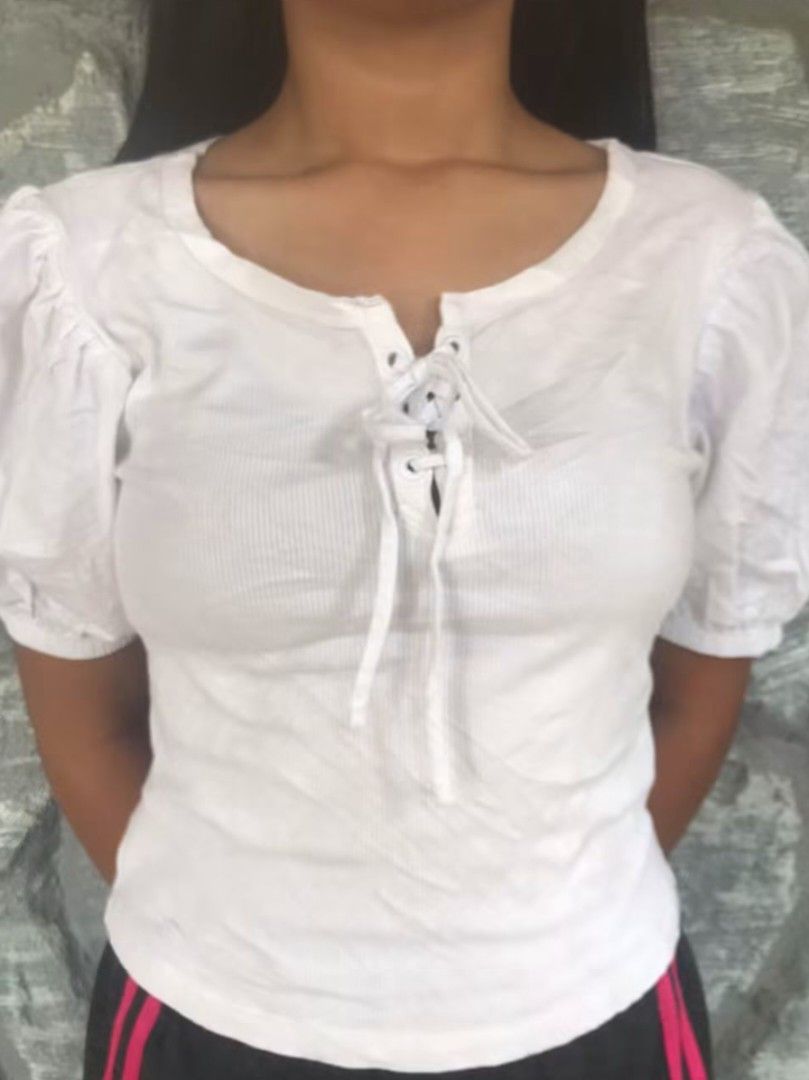 GAP White Ribbed Lace-Up Puff Sleeve Top (Category: Blouses) located in Manila. Submitted by thrifttruss101 (Listing ID 1467738215, Image 1). Description: - Brand/Model: GAP white ribbed top - Size: XS-S - Details: Puff sleeves, scooped neckline, front lace-up closure with white ties - Fabric: Lightweight knit - Condition: Worn a few times, solid shape - Styling: Easy to match with jeans or skirts.