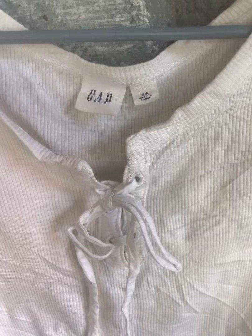 GAP White Ribbed Lace-Up Puff Sleeve Top (Category: Blouses) located in Manila. Submitted by thrifttruss101 (Listing ID 1467738215, Image 2). Description: - Brand/Model: GAP white ribbed top - Size: XS-S - Details: Puff sleeves, scooped neckline, front lace-up closure with white ties - Fabric: Lightweight knit - Condition: Worn a few times, solid shape - Styling: Easy to match with jeans or skirts.