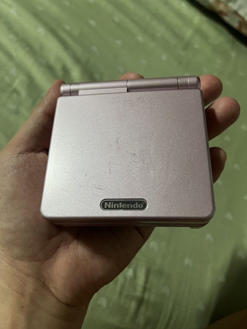 GBA SP AGS-101 Pearl Pink Bundle (Category: Nintendo) located in Marikina City. Submitted by jaydxgamer (Listing ID 1467741623, Image 3). Description: - Model: Nintendo Game Boy Advance SP AGS-101 (Pearl Pink) - Screen: Bright backlit screen, fully functional - Condition: Shell has visible surface scratches from normal use; everything tested and works great - Games included: Pac-Man World 2, The Wild, and Flushed Away - Accessories: AC adapter an