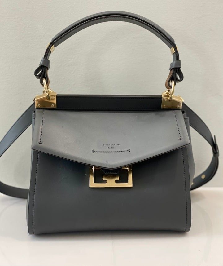 Givenchy Mystic Small Leather Satchel Bag Grey (Category: Luxury Bags & Wallets) located in San Juan City. Submitted by swiftfox.62e2f4 (Listing ID 1467732899, Image 1). Description: - Brand: Givenchy - Model: Mystic Handbag - Color: Dark Grey with gold-tone hardware - Material: Premium leather with suede and light leather interior - Closure: Unique geometric flap closure - Features: Top handle, adjustable/removable shoulder strap, interior zippe
