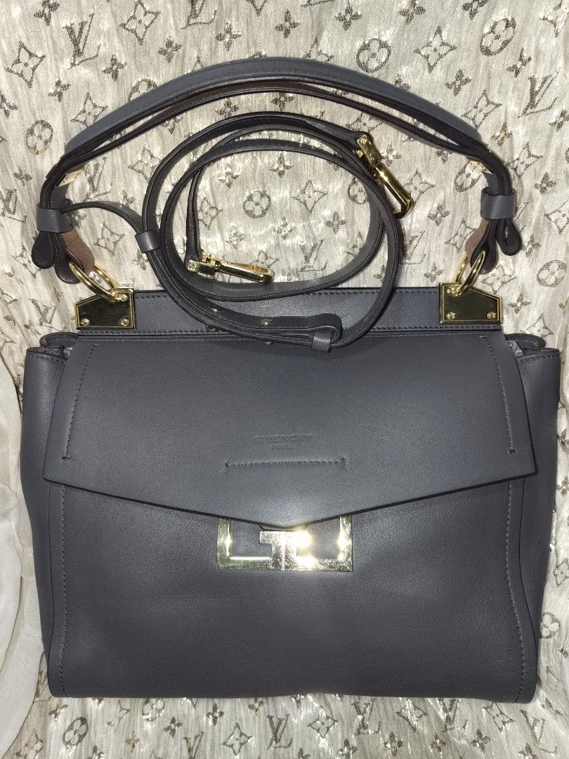 Givenchy Mystic Small Leather Satchel Bag Grey (Category: Luxury Bags & Wallets) located in San Juan City. Submitted by swiftfox.62e2f4 (Listing ID 1467732899, Image 2). Description: - Brand: Givenchy - Model: Mystic Handbag - Color: Dark Grey with gold-tone hardware - Material: Premium leather with suede and light leather interior - Closure: Unique geometric flap closure - Features: Top handle, adjustable/removable shoulder strap, interior zippe