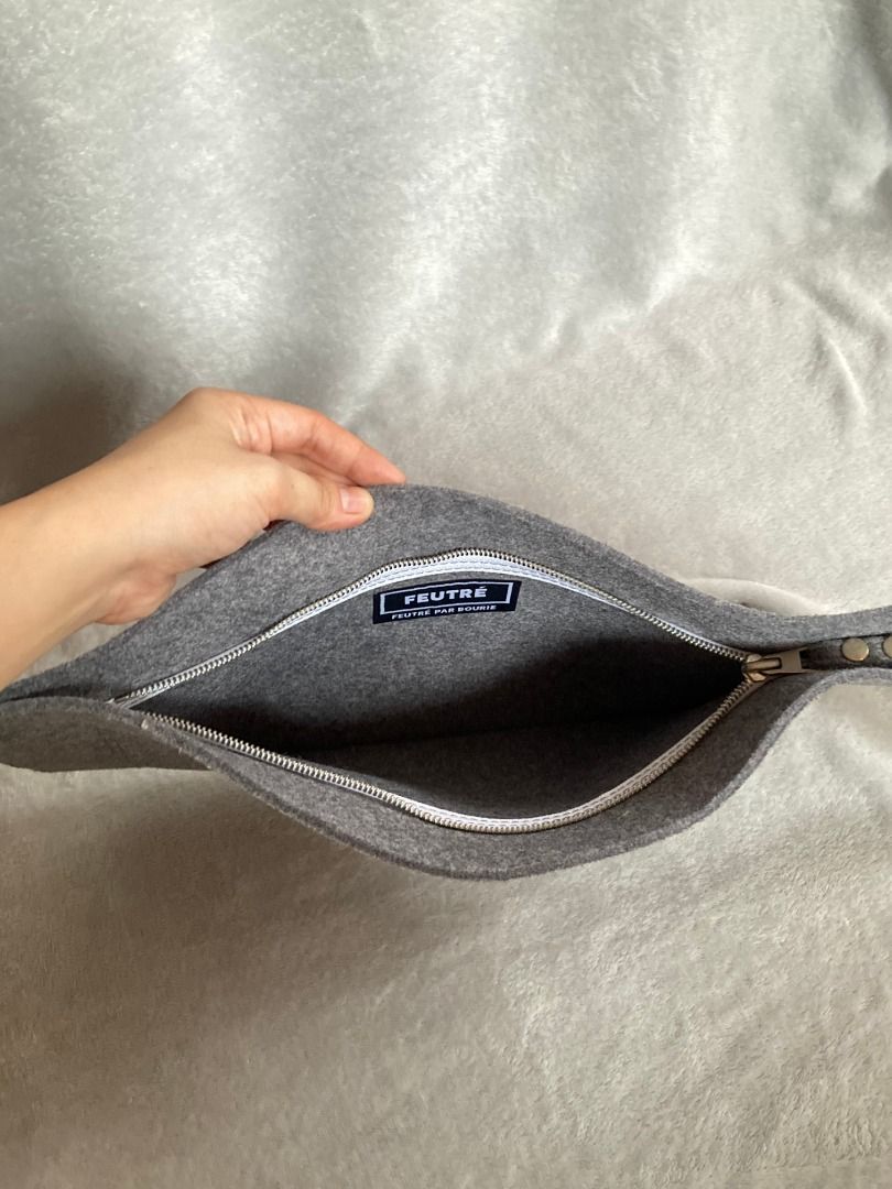 Grey Felt Zip Pouch Clutch (Category: Purses & Pouches) located in Rizal. Submitted by sheeraay (Listing ID 1467706943, Image 2). Description: - Brand: FEUTRÉ - Material: Soft grey felt with clean interior lining - Closure: Smooth silver top zipper - Design: Minimalist and slim profile - Details: Stitched brand label inside - Condition: Excellent.